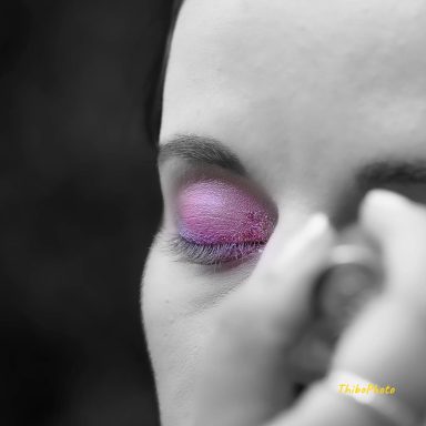 Maquillage artistique avec un accent sur une ombre à paupières rose vif.