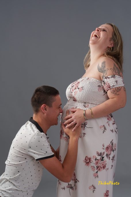 Un couple heureux au moment de la grossesse, l'homme souriant en touchant le ventre de la femme.