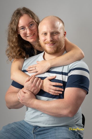 Un homme et une femme souriants s'enlacent, montrant leur complicité.