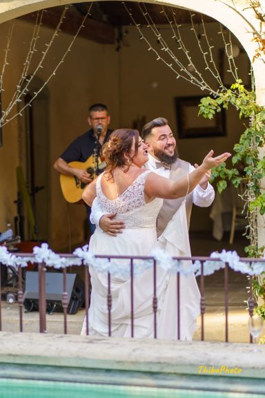 Un couple danse lors de leur mariage, avec un musicien en arrière-plan.
